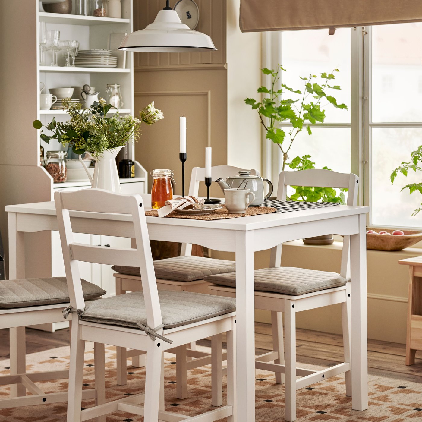 Una taula HAUGA blanca i quatre cadires HAUGA blanques en un menjador d'estil rústic modern.