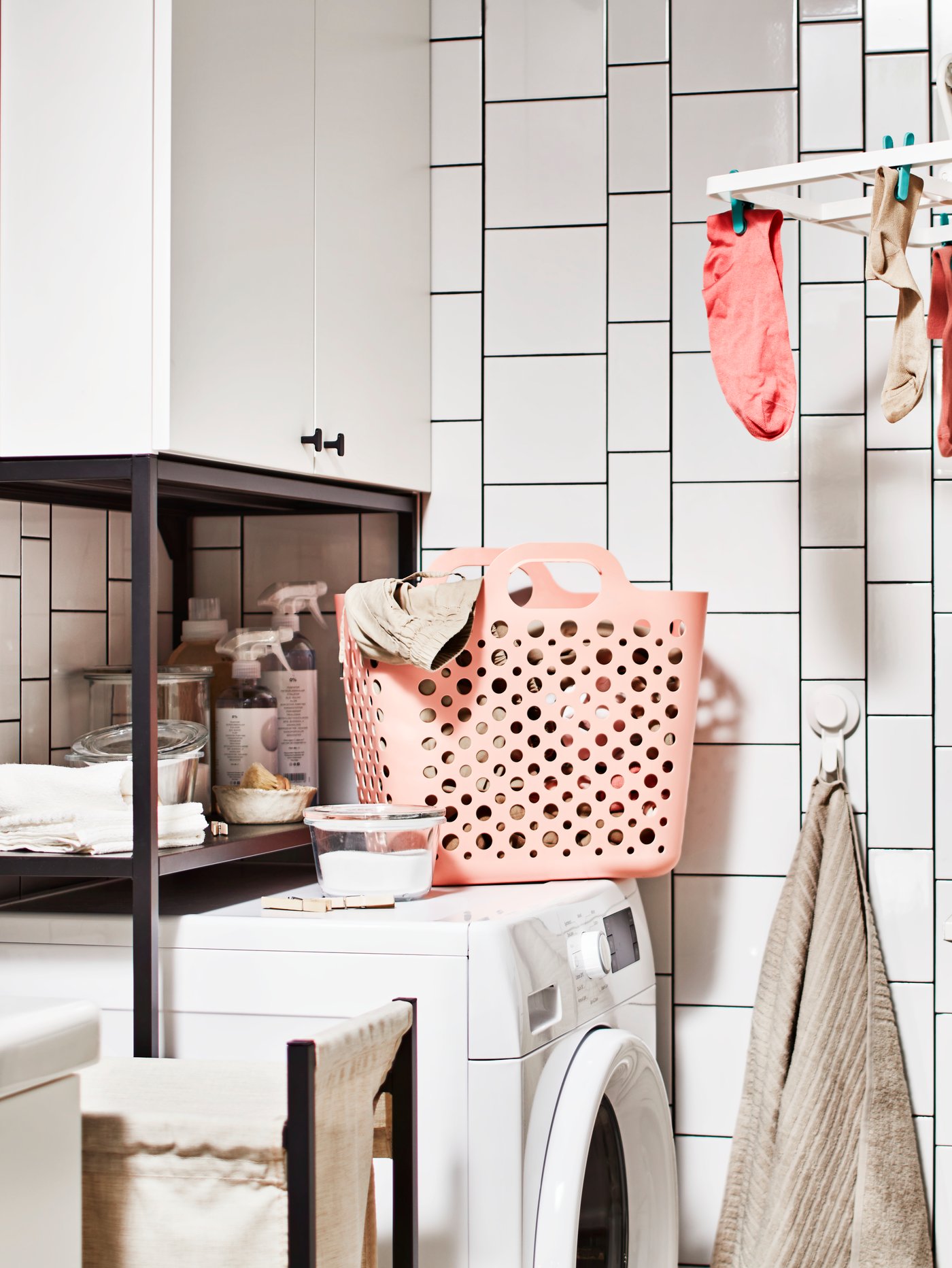 Eine im Badezimmer eingerichtete Waschküche mit Waschmaschine, Aufbewahrung für Wäsche mit Schrank und einer Wäschekombination mit Boden.