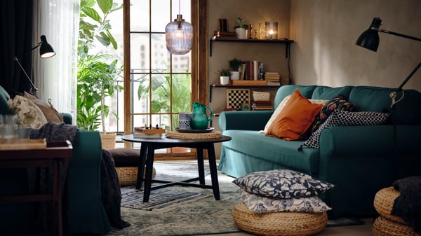 A living room with a blue sofa and ambient lighting.