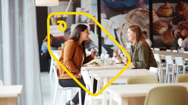 Deux jeunes femmes attablées dans un restaurant IKEA et souriantes