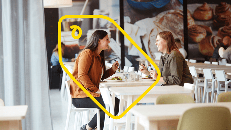 Deux jeunes femmes attablées dans un restaurant IKEA et souriantes