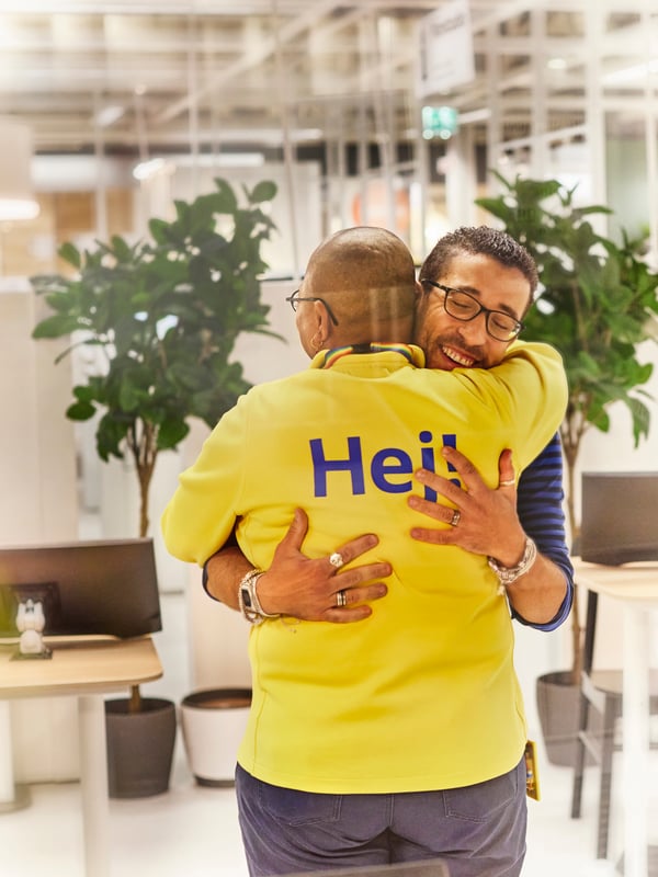 Two IKEA co-workers hugging.