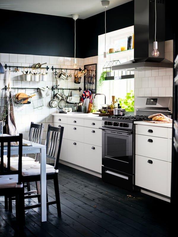 A kitchen with white SEKTION base cabinets, an EKBACKEN worktop, a MOTSVARIG range with gas cooktop, and dark wood floor.
