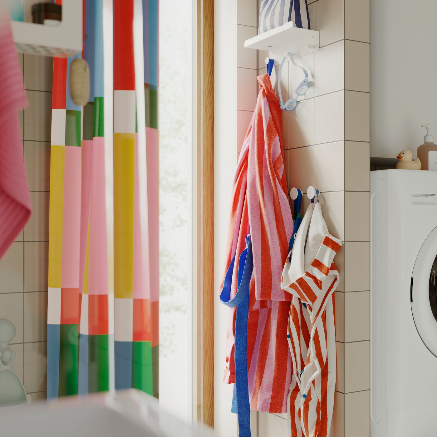 A bathroom with an ENUDDEN wall shelf with 3 hooks, holding striped towels and colourful robes on a tiled wall.