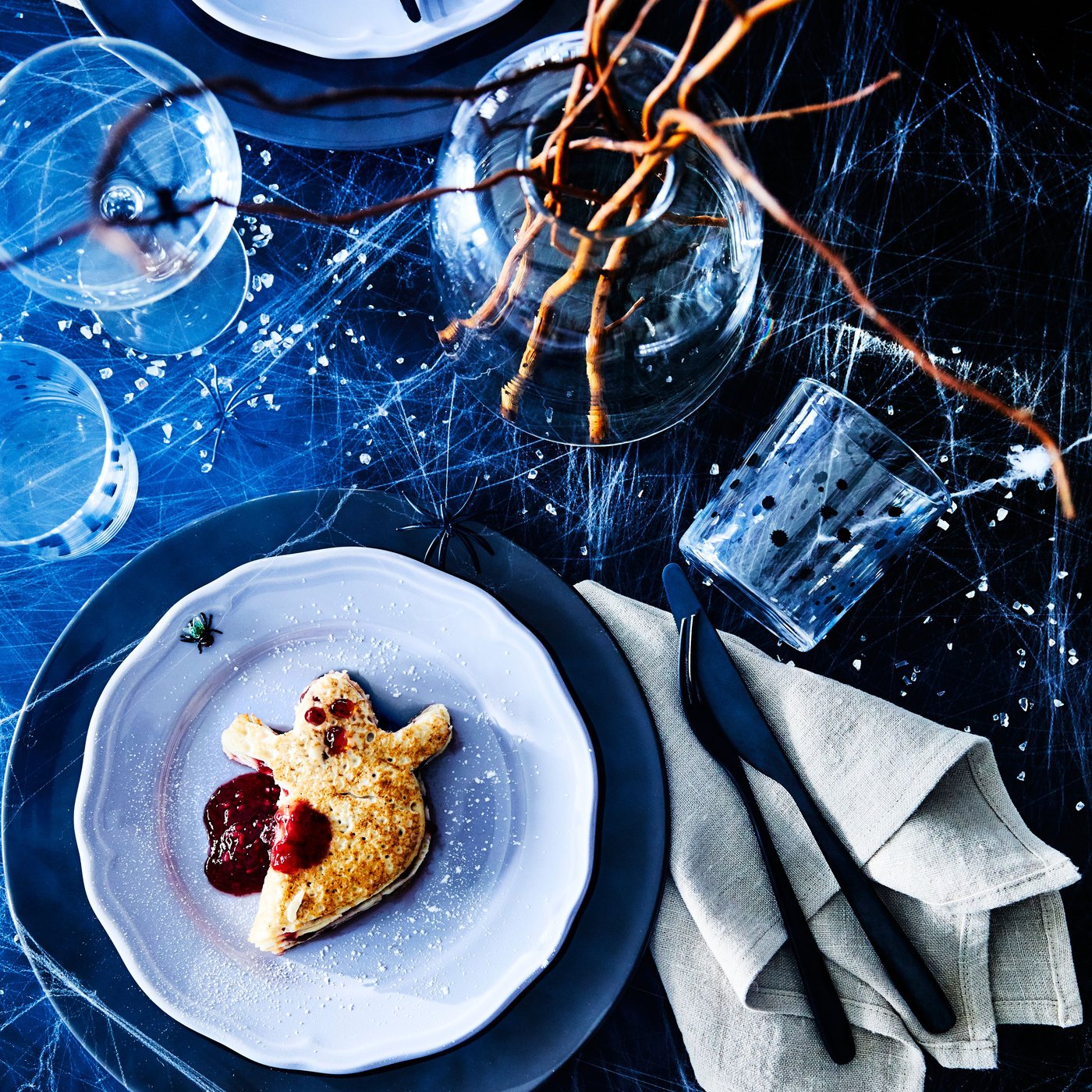 En pannkaka som är formad till ett halloweenspöke ligger på en tallrik.