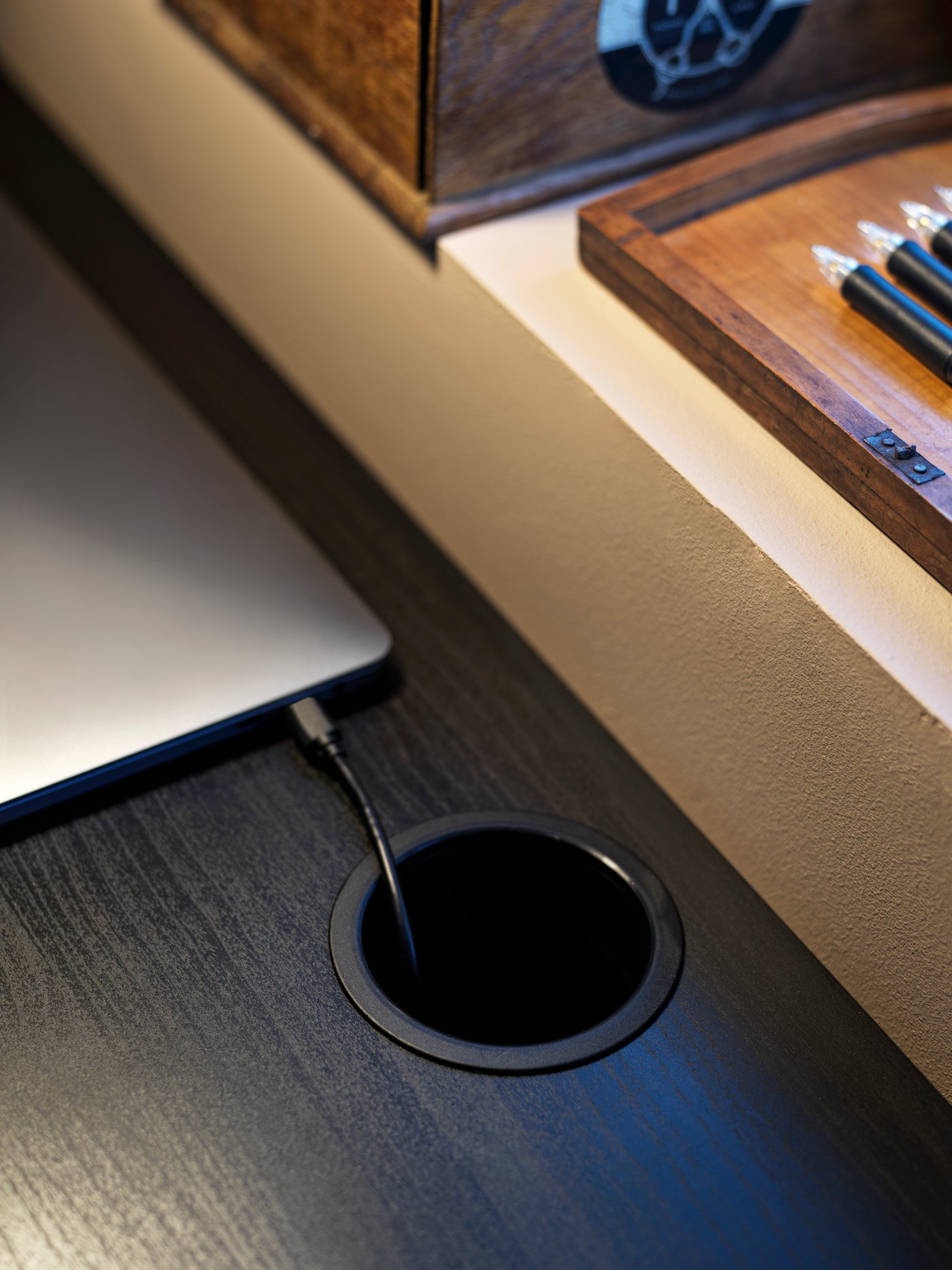 Een zwart-bruin MICKE bureau met een handige manier om snoeren weg te werken.