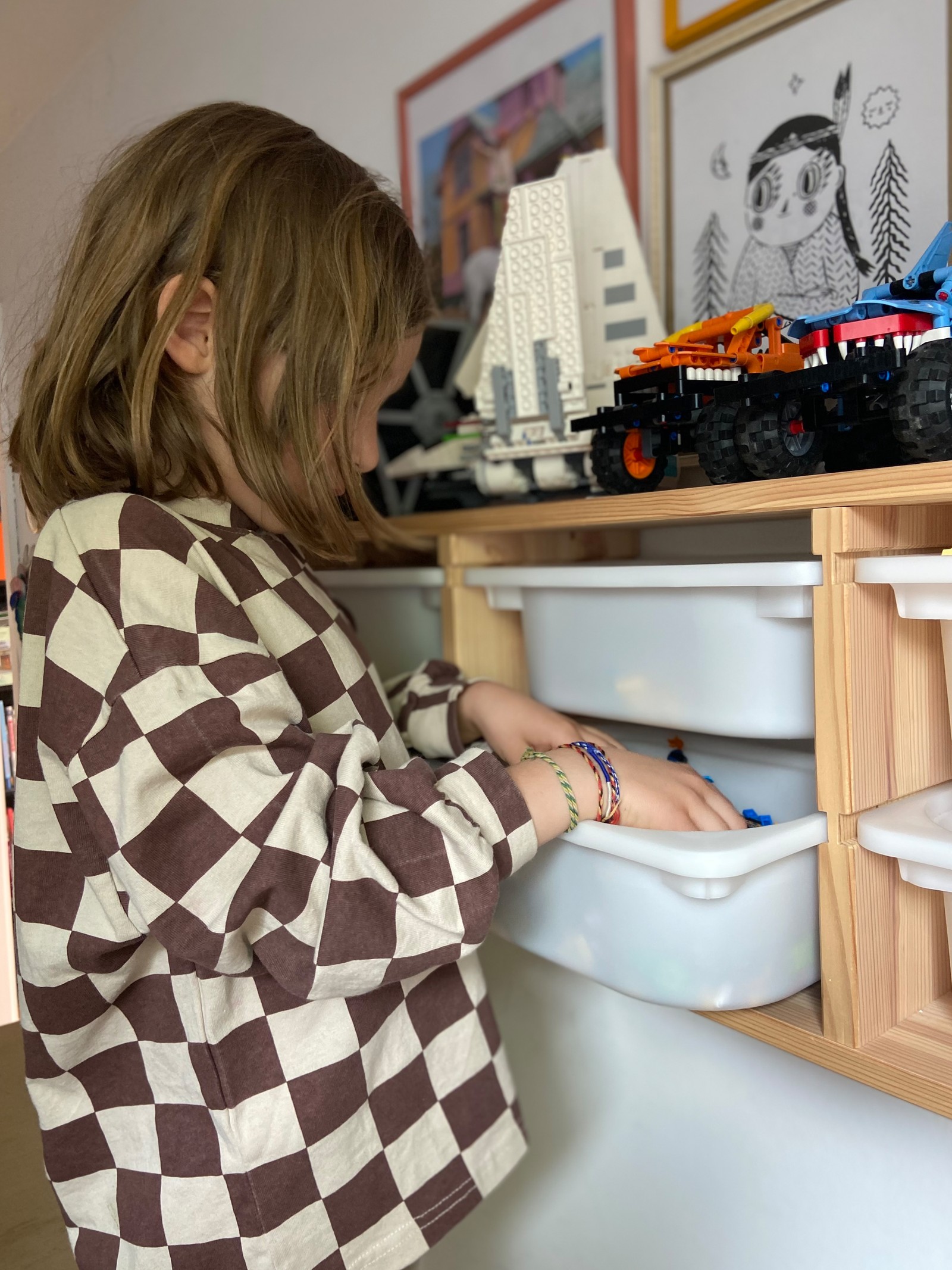 Annina ćerka poseže da uzme zalihe s polica s kutijama.