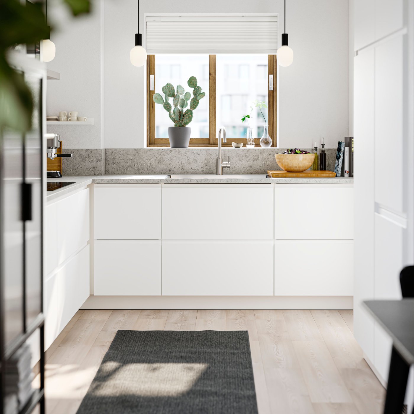 Une cuisine blanche avec un tapis gris au sol