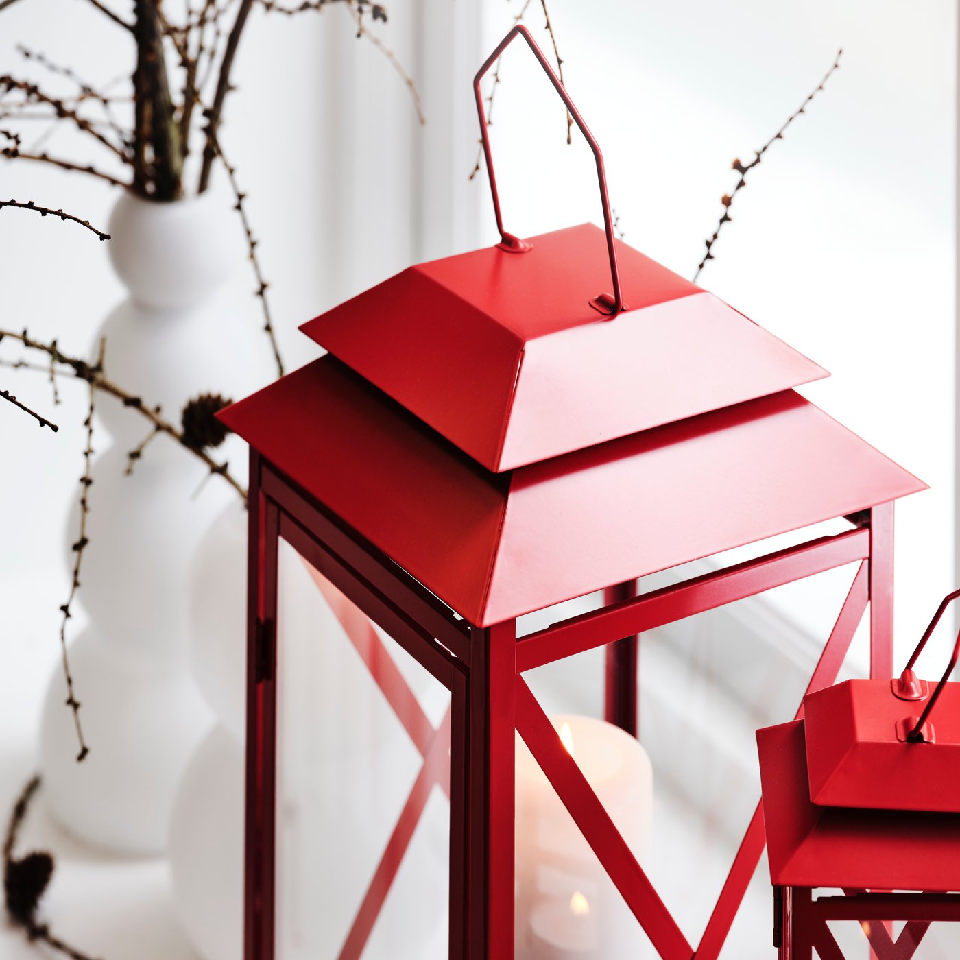 A bright red VINTERFINT lantern for tealight, in/outdoor