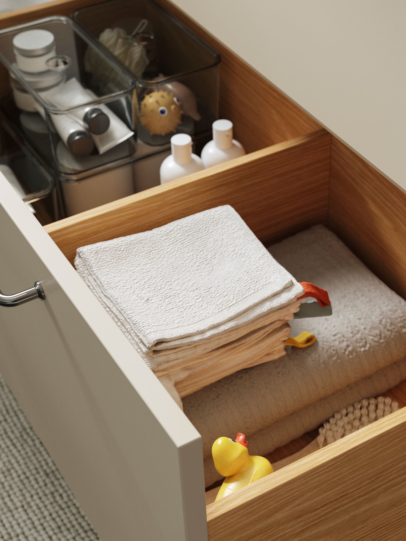 El cajón de un gabinete de baño abierto y en el interior cajas organizadoras VISSLAÅN con diferentes artículos y accesorios.