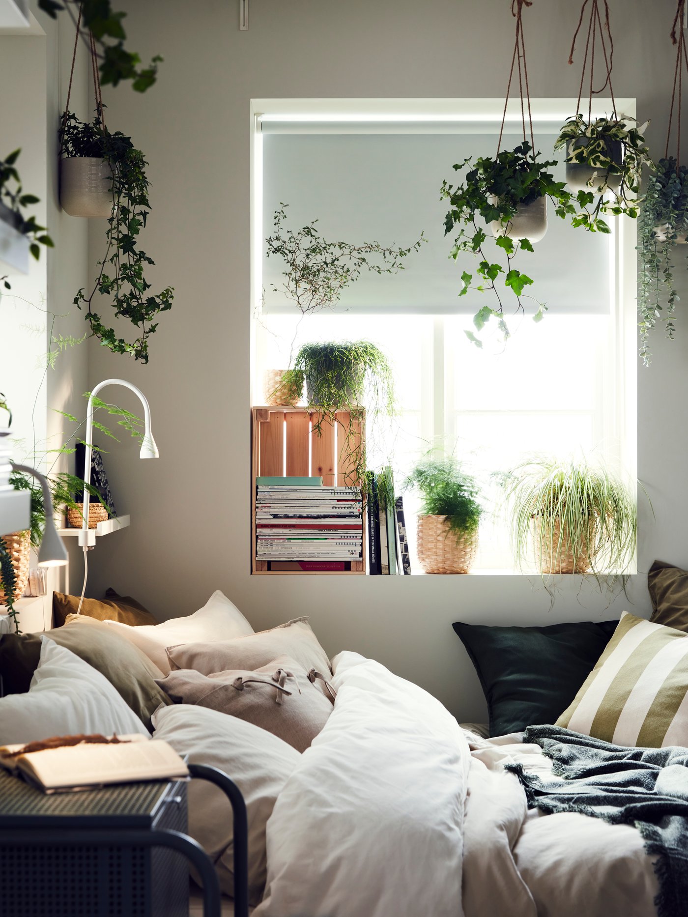 Ein weißer NÄVLINGE LED‑Wand‑/Klemmspot im Schlafzimmer.