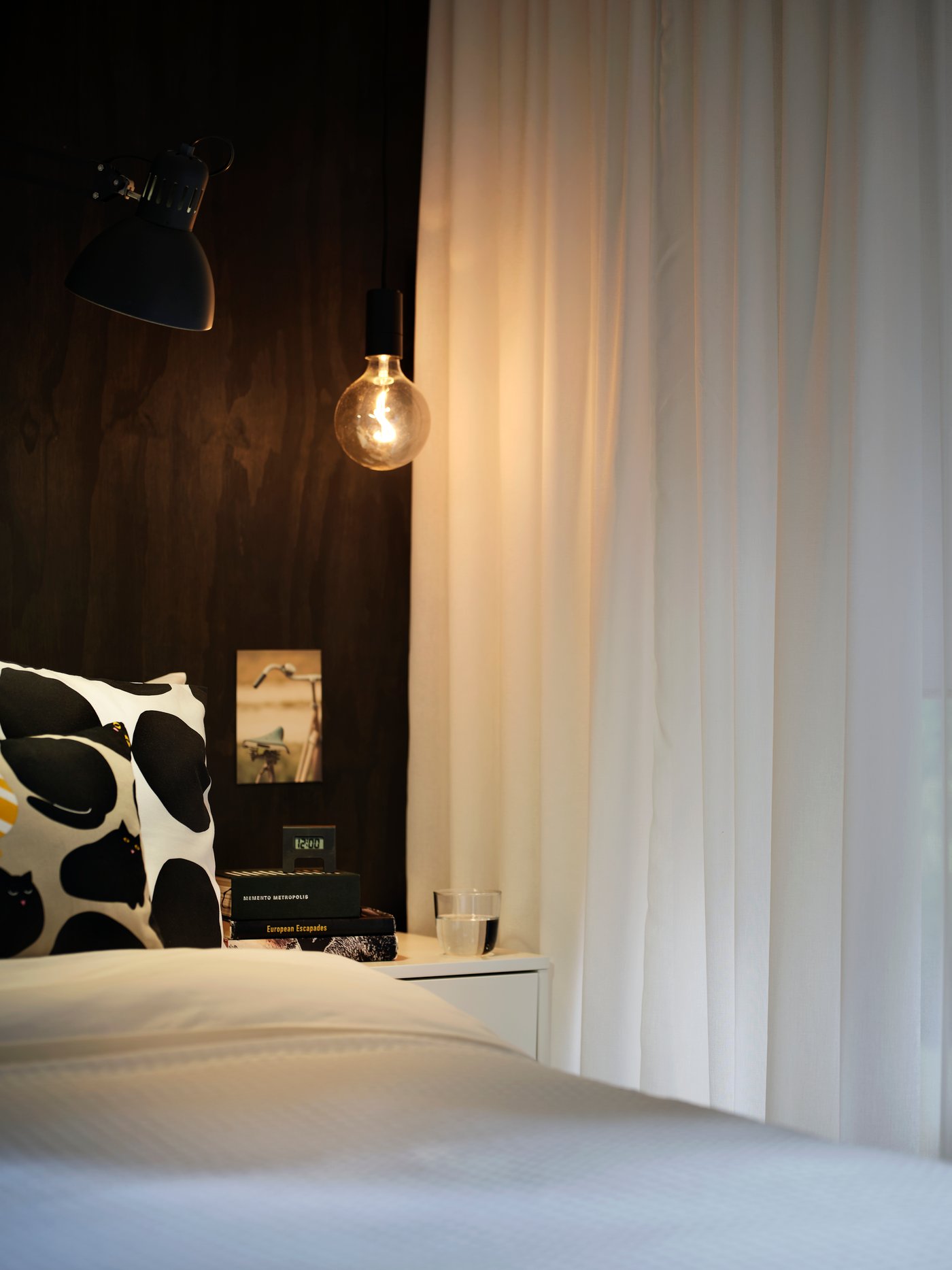 ROSENROBINIA Gardinen sind als Raumteiler in einem Schlafzimmer zu sehen.