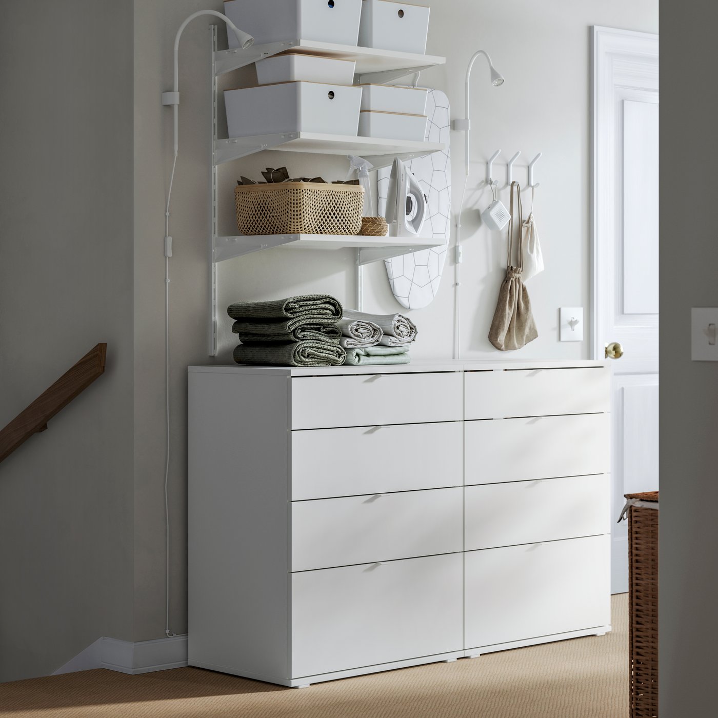 VIHALS chests of drawers, along with open shelving and storage boxes, form a laundry sorting station on a stair landing.