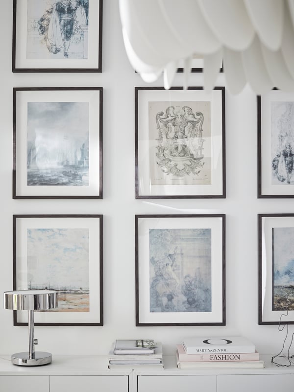IKEA HOVSTA dark brown frames arranged evenly on a white living room wall.