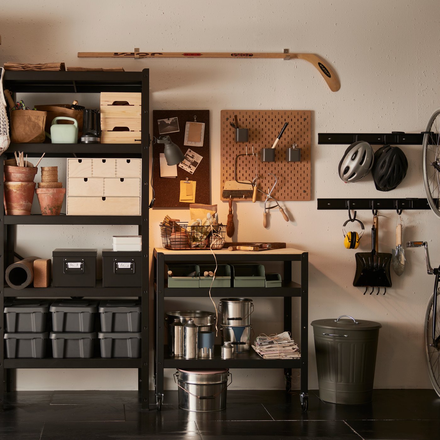 Eine Wand mit einem schwarzen Regal voller Kästen und Boxen aus Holz, Pappe und Kunststoff in verschiedenen Größen.