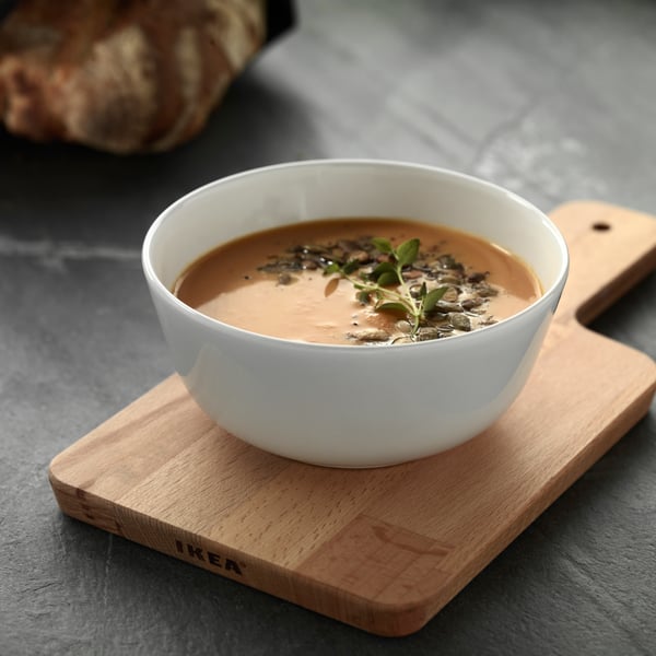 bol rempli de soupe avec une planche à decouper en dessous