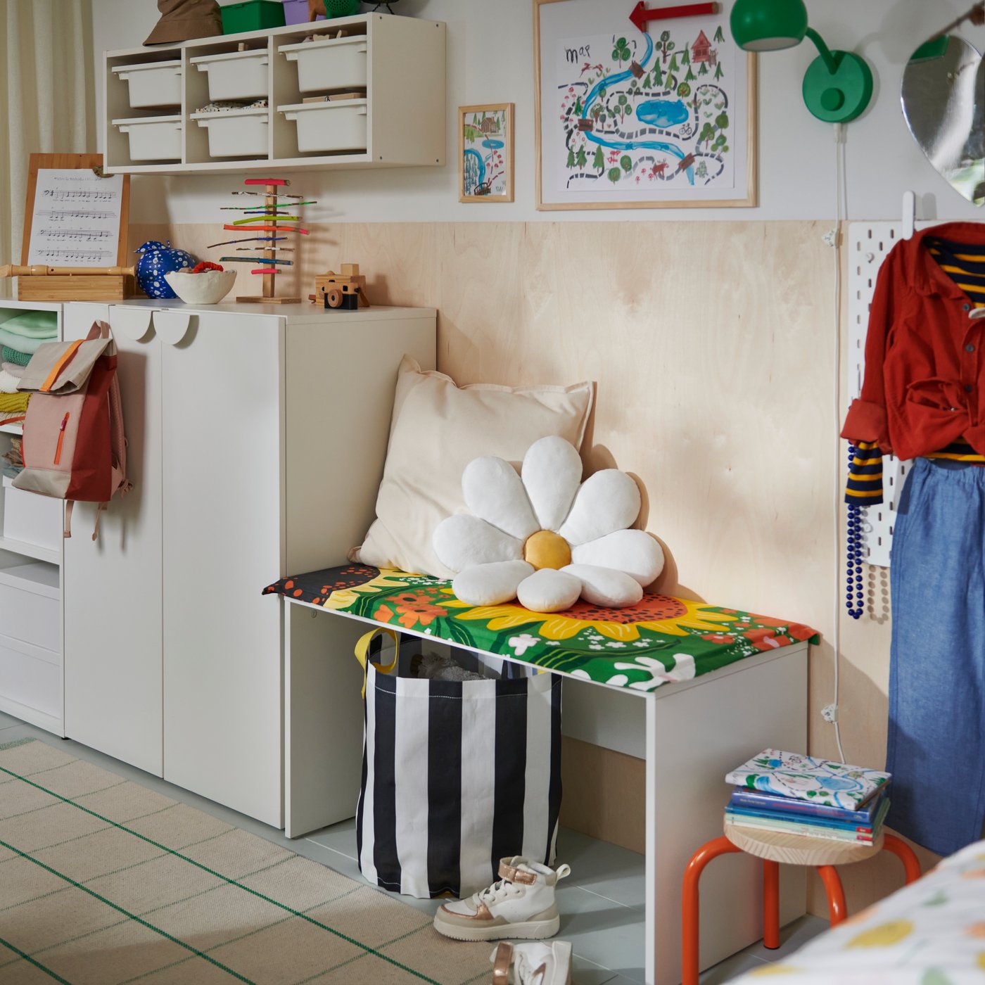 A child’s room featuring a LASTARE wardrobe combination flanked by a small white desk with a flower-shaped pillow.