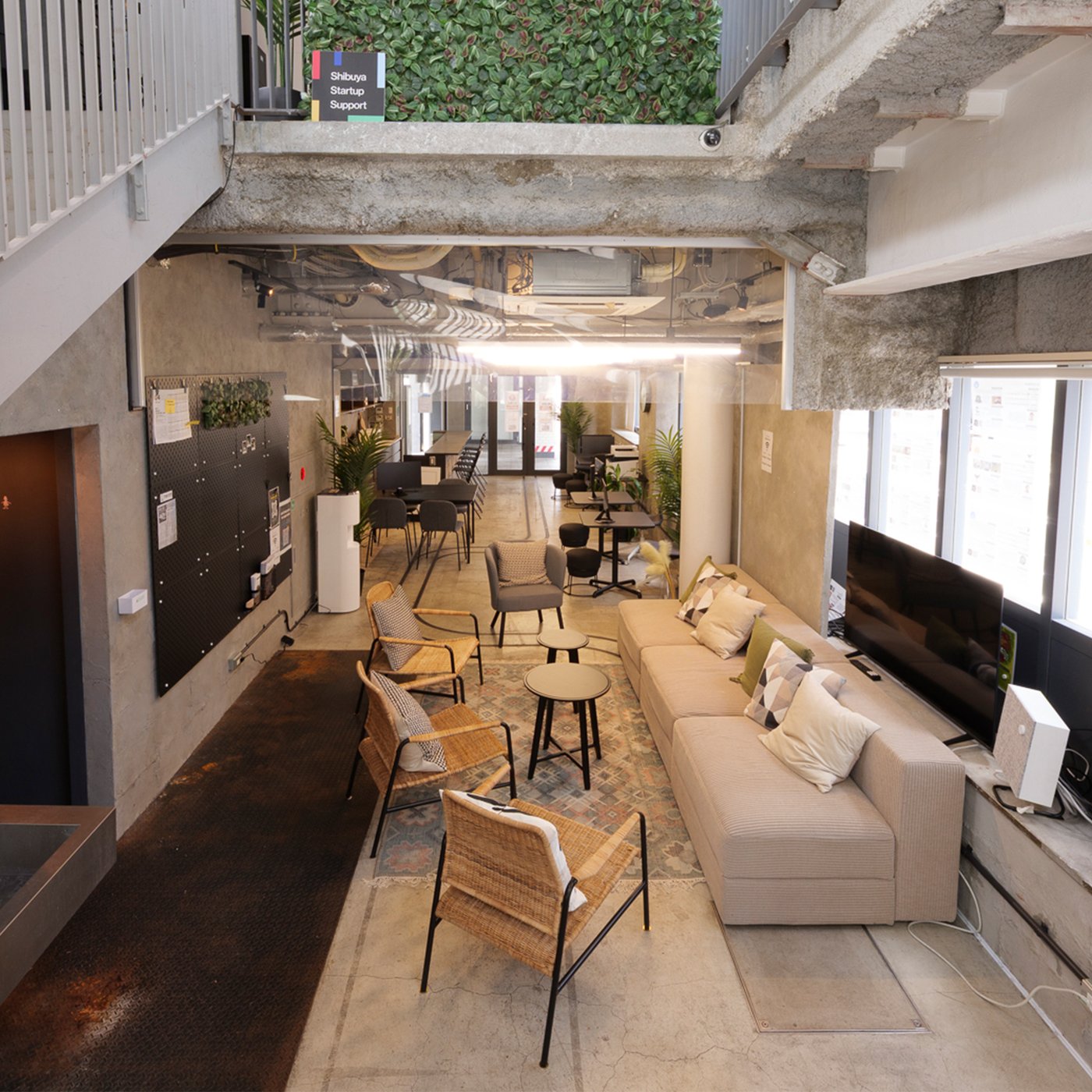 工業的デザインの開放的な室内空間。自然光が差し込む窓と多様な席が協働や交流に最適