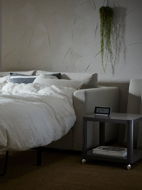Bedroom with a VIMLE 2-seat sofa-bed, side table on castors, cushion cover, and duvet cover with two pillowcases.