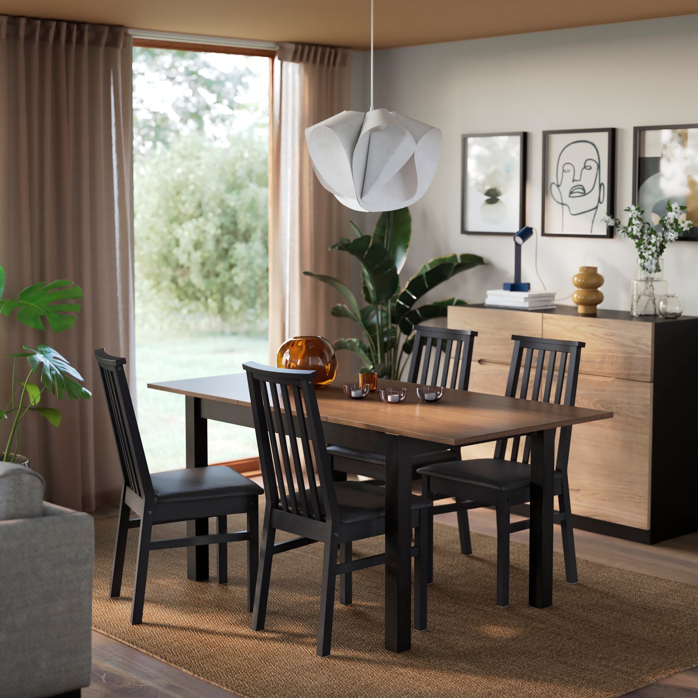 Zona pranzo accogliente con tavolo rettangolare ÅLHULT, effetto rovere e struttura nera abbinato a 4 sedie coordinate, ideale per cene rilassate e luminose viste sul giardino.
