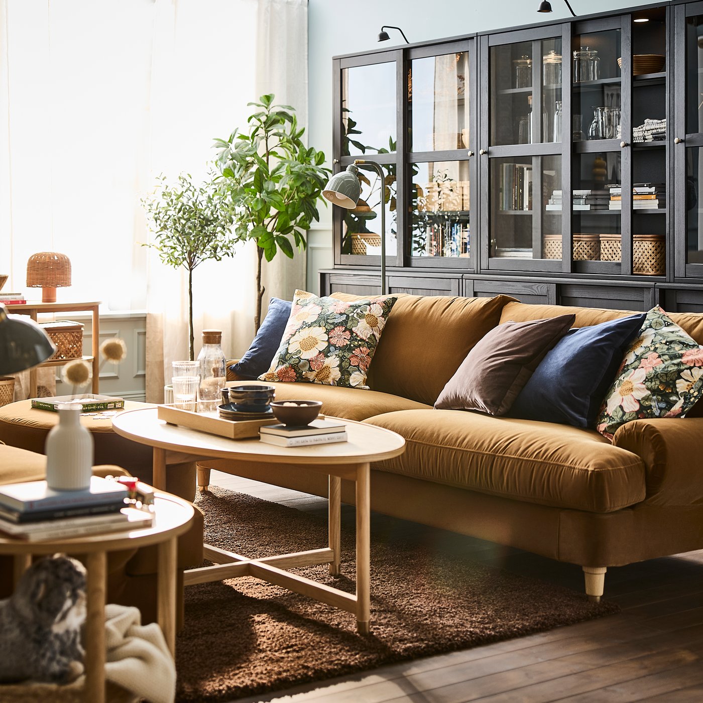 En stue med en brun treseters sofa, kombinert med et sofabord i tre og dekorative detaljer.