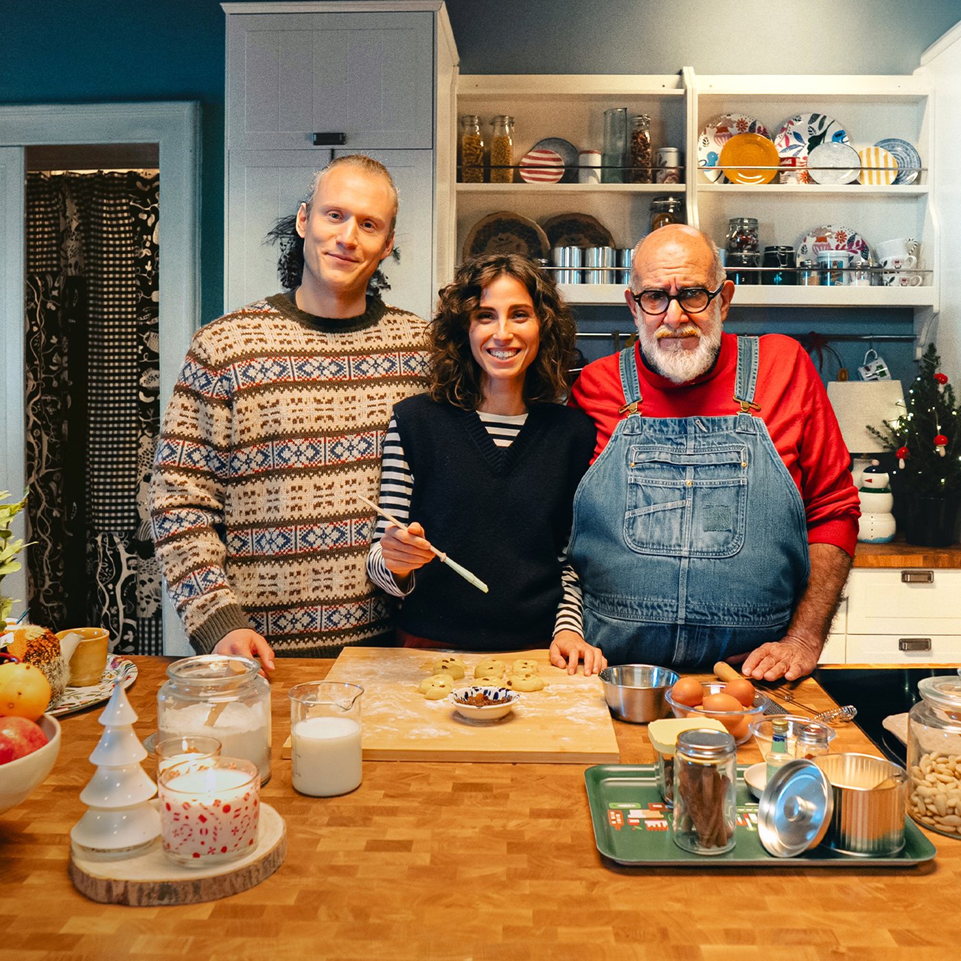 Giorgione e la famiglia Larsson preparano sorridenti dei dolci natalizi in una cucina accogliente.