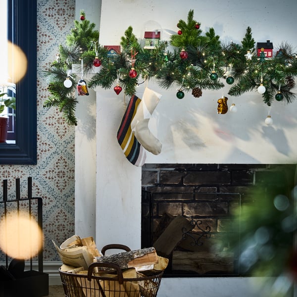 An in/outdoor/pine cone VINTERFINT artificial garland decorated with Christmas socks and baubles.