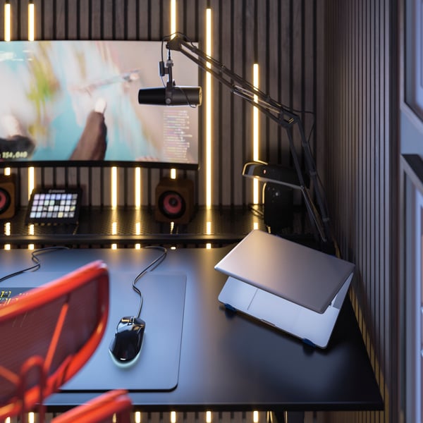 In a gaming nook, an UTESPELARE gaming desk is kitted with a LÅNESPELARE gaming mouse pad and LÅNESPELARE laptop support.