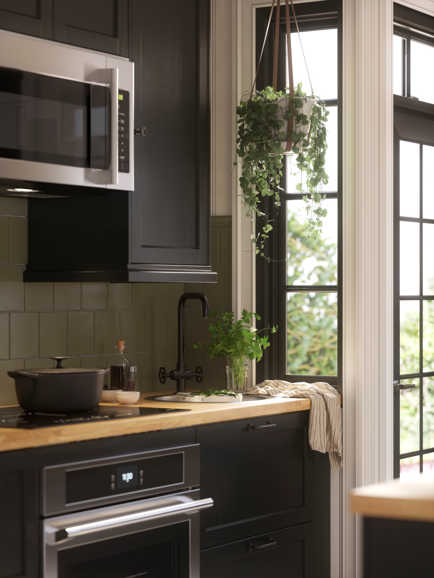 Cocina equipada con una encimera KARLBY para isla de cocina, una cazuela VARDAGEN con tapa y un paño de cocina MARIATHERES.