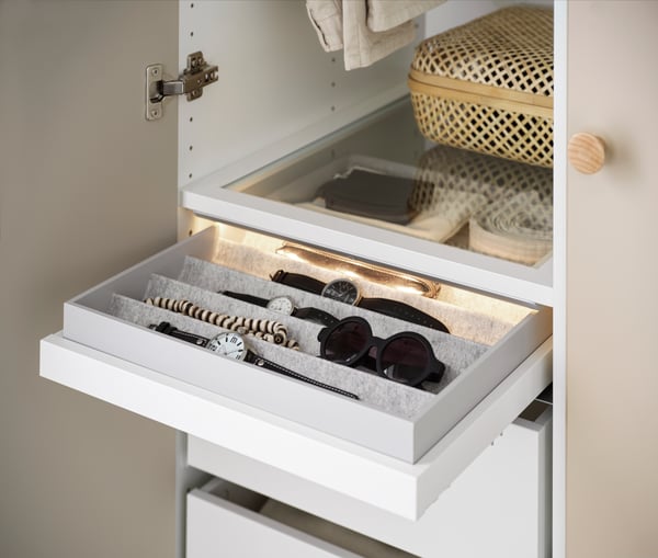 A white KOMPLEMENT glass shelf in the bedroom