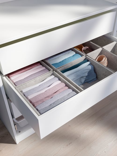 Close-up of an open KOMPLEMENT drawer with several KOMPLEMENT boxes containing folded clothes.