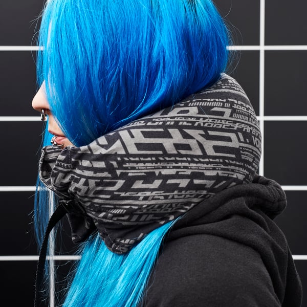 A blue-haired girl in profile, wearing a LÅNESPELARE neck pillow.