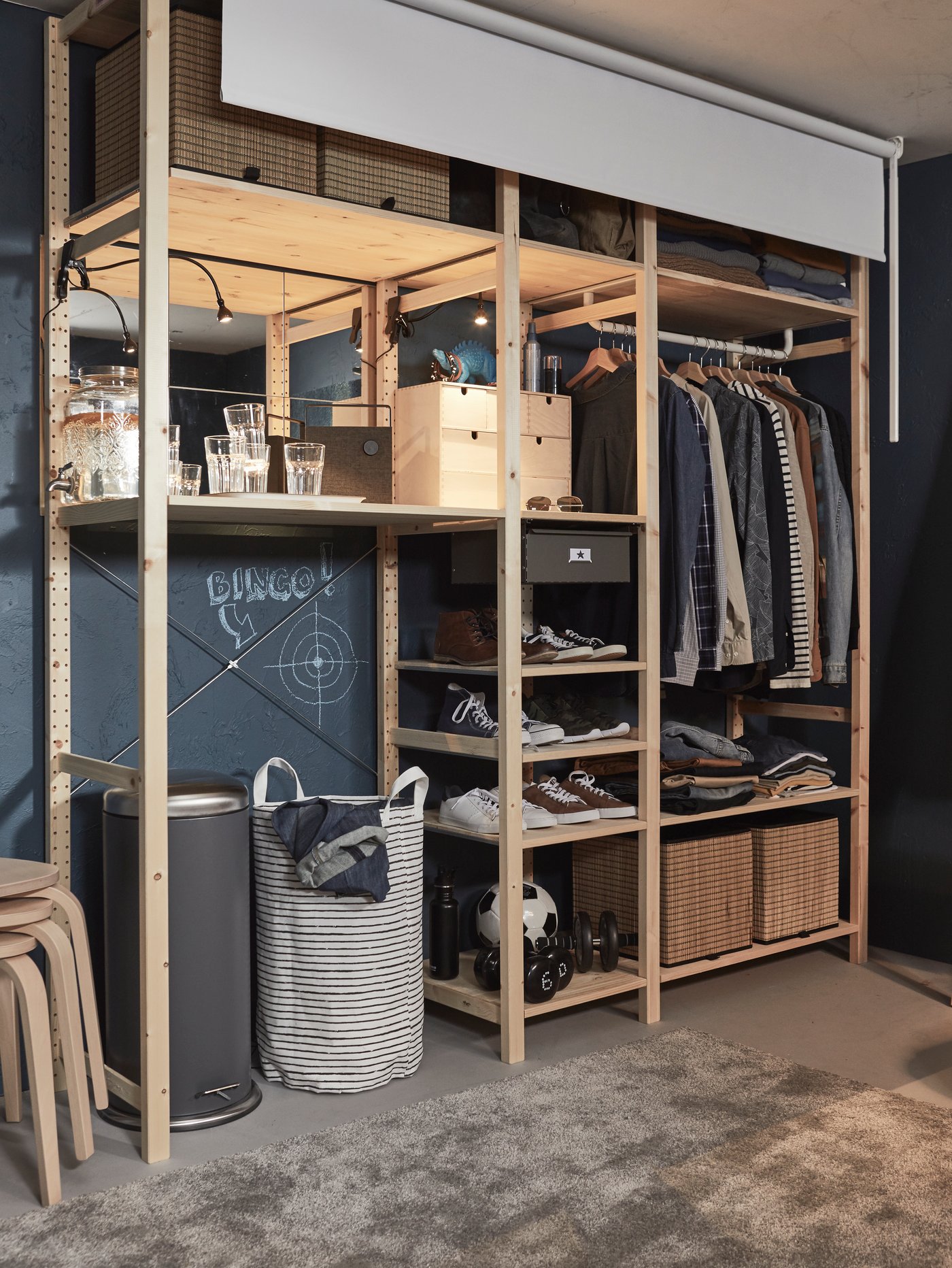 Stor IVAR förvaringskombination med kläder, lådor och skor. FRIDANS rullgardin kan dras ner för att dölja den.