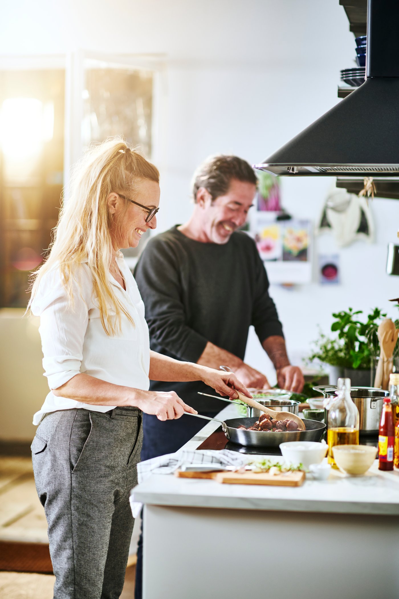 Two people are cooking HUVUDROLL plant balls in the kitchen