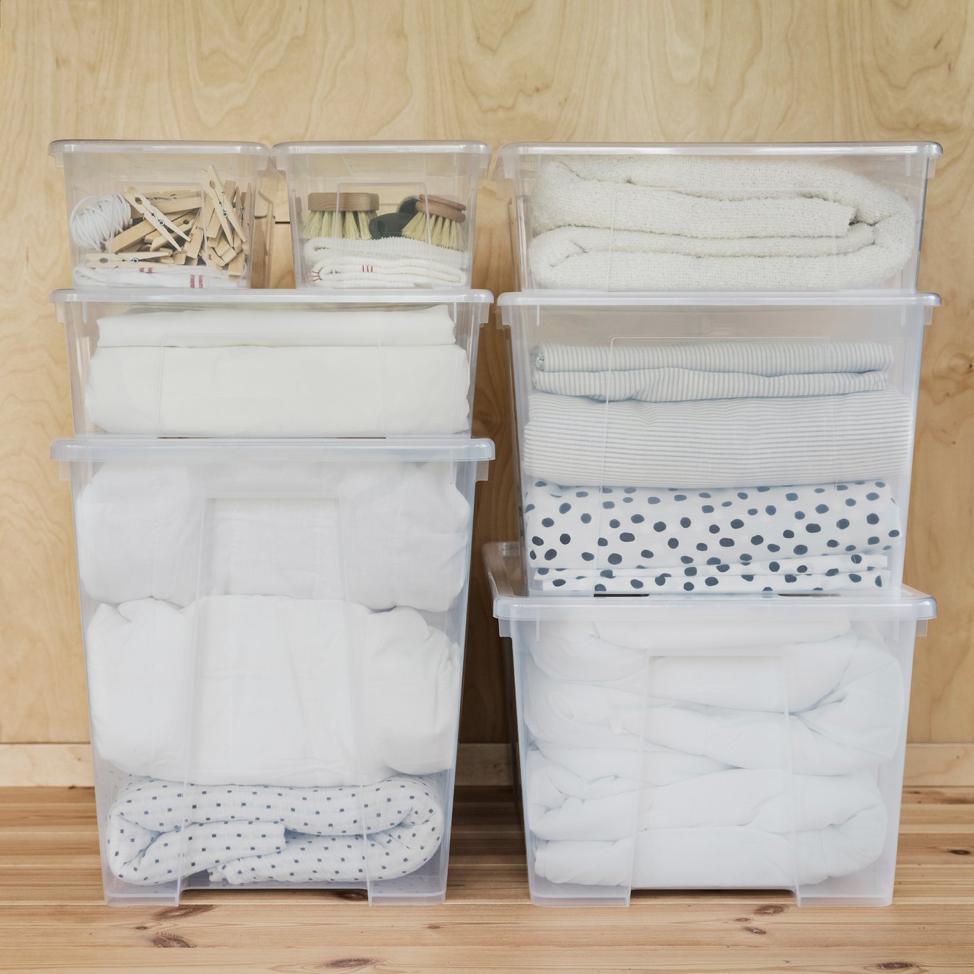 SAMLA boxes, stacked up, full of clothes and bedding. 