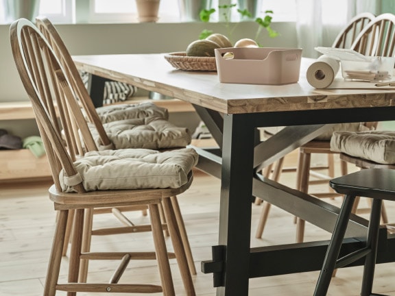 An acacia/black SKOGSTA dining table