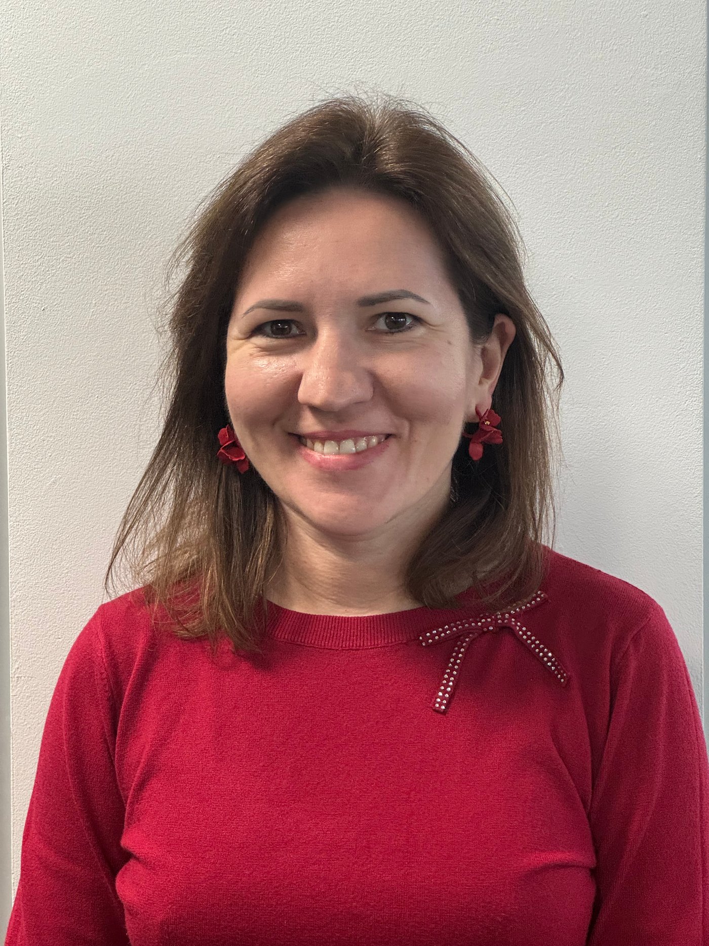 Olena in a red sweater smiling to the camera.