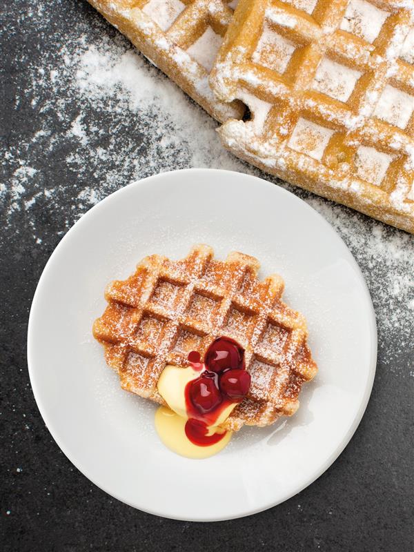 Eine Waffel mit Vanillesauce und Beeren