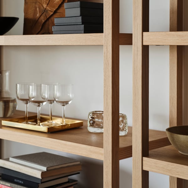 An oak veneer STOCKHOLM 2025 shelving unit in the living room