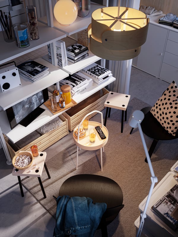 An overhead view of a lounge area with two black FRÖSET easy chairs facing each other and a BURVIK side table in between.