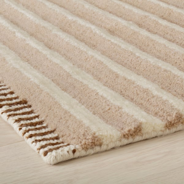 A white/beige TÅGSPÅR striped rug, high pile