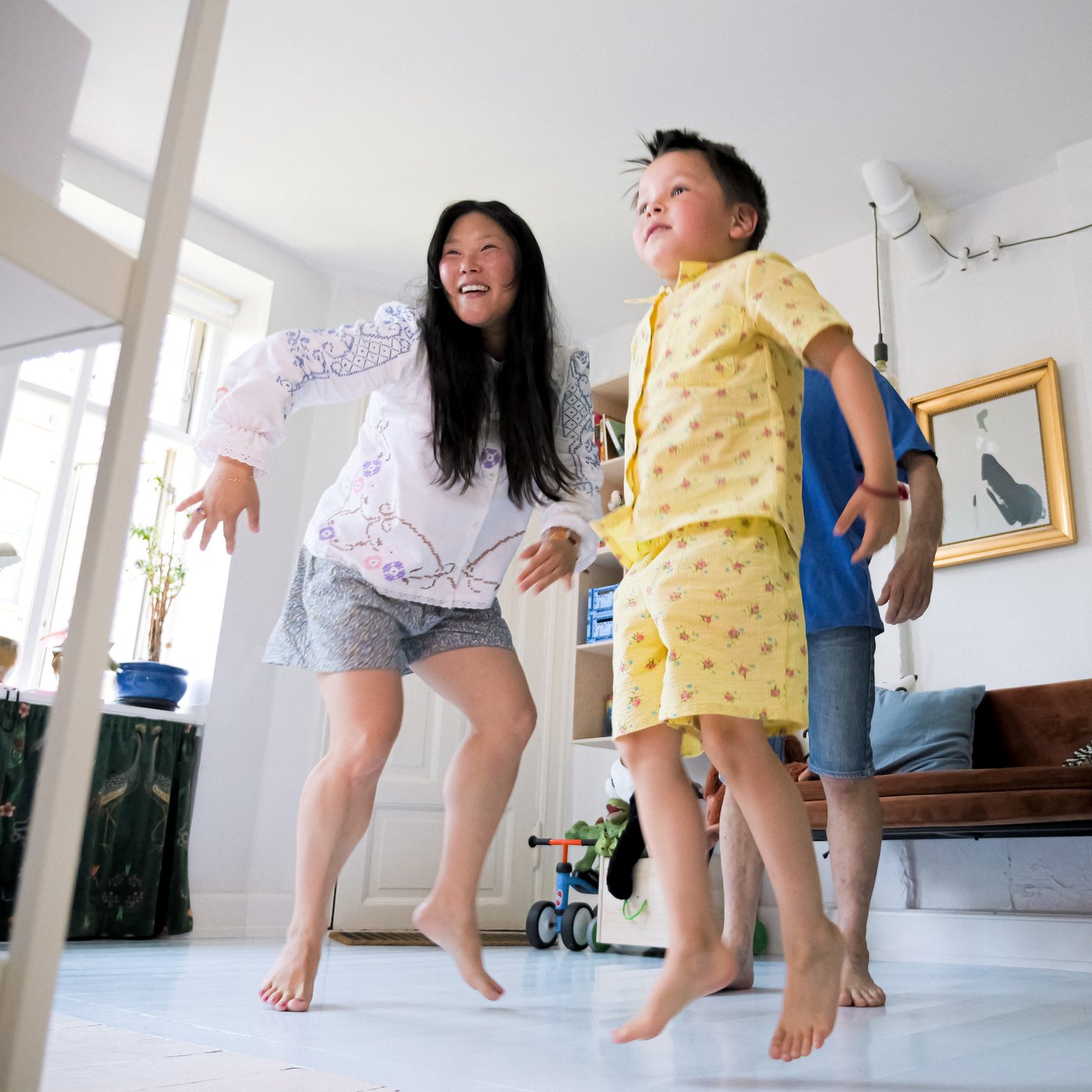 A mother, father and child dance in front of a smart phone in a LÅNESPELARE ring light with phone holder