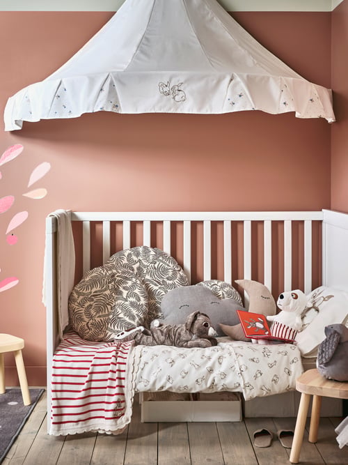 Baby and children room with a sateen duvet cover with 1 pillowcase for cot placed in a white cot, under a white bed canopy.