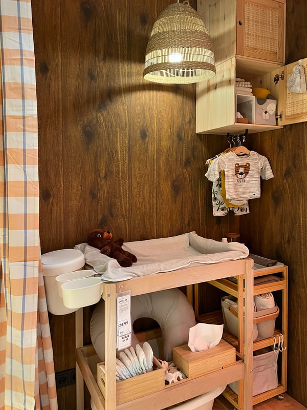 A wooden changing table with all kinds of storage options under and attached to the table