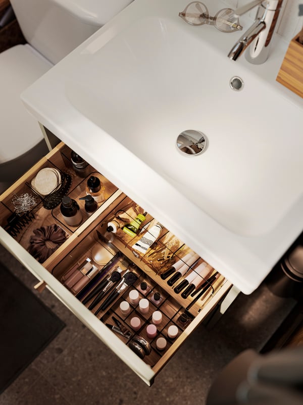 The top drawer of a beige HAVBÄCK wash-stand is pulled out and there are VISSLAÅN boxers and drawer organisers inside..