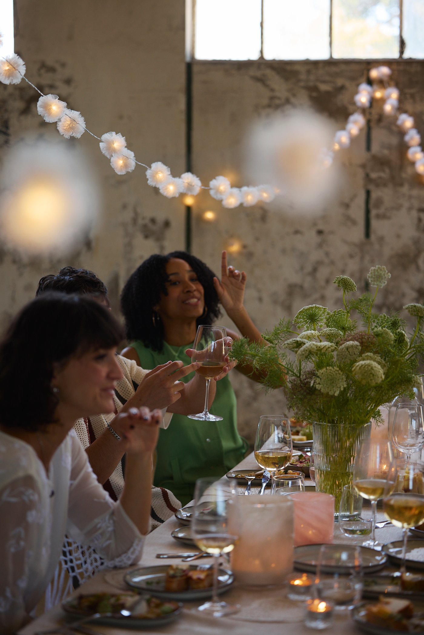 People spend time and socialize with each other around a dinner table, laughing, toasting and having fun.