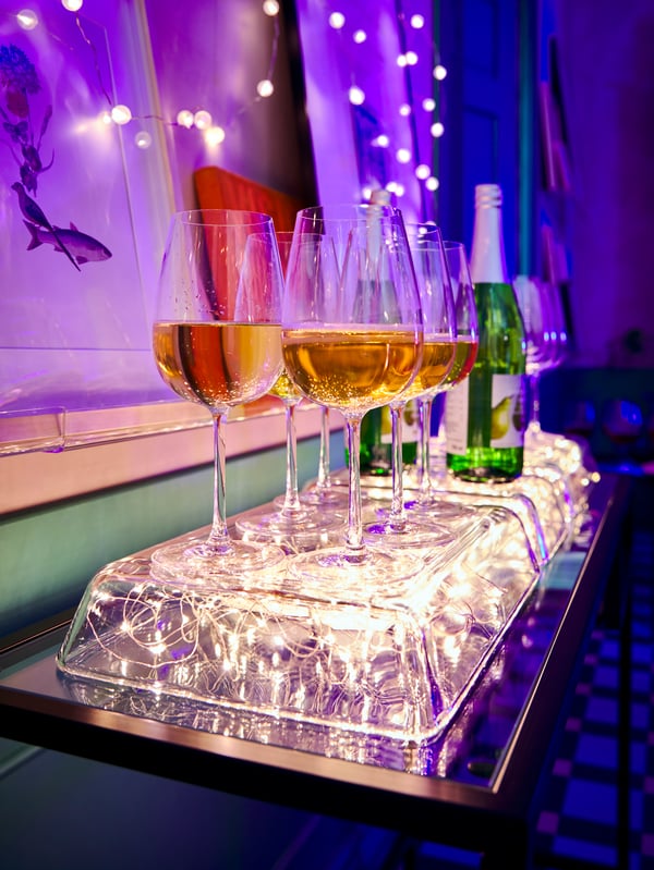 Two glass tuperwares sits on top of two boxes with strings of lights. There are purple and blue lights in the background