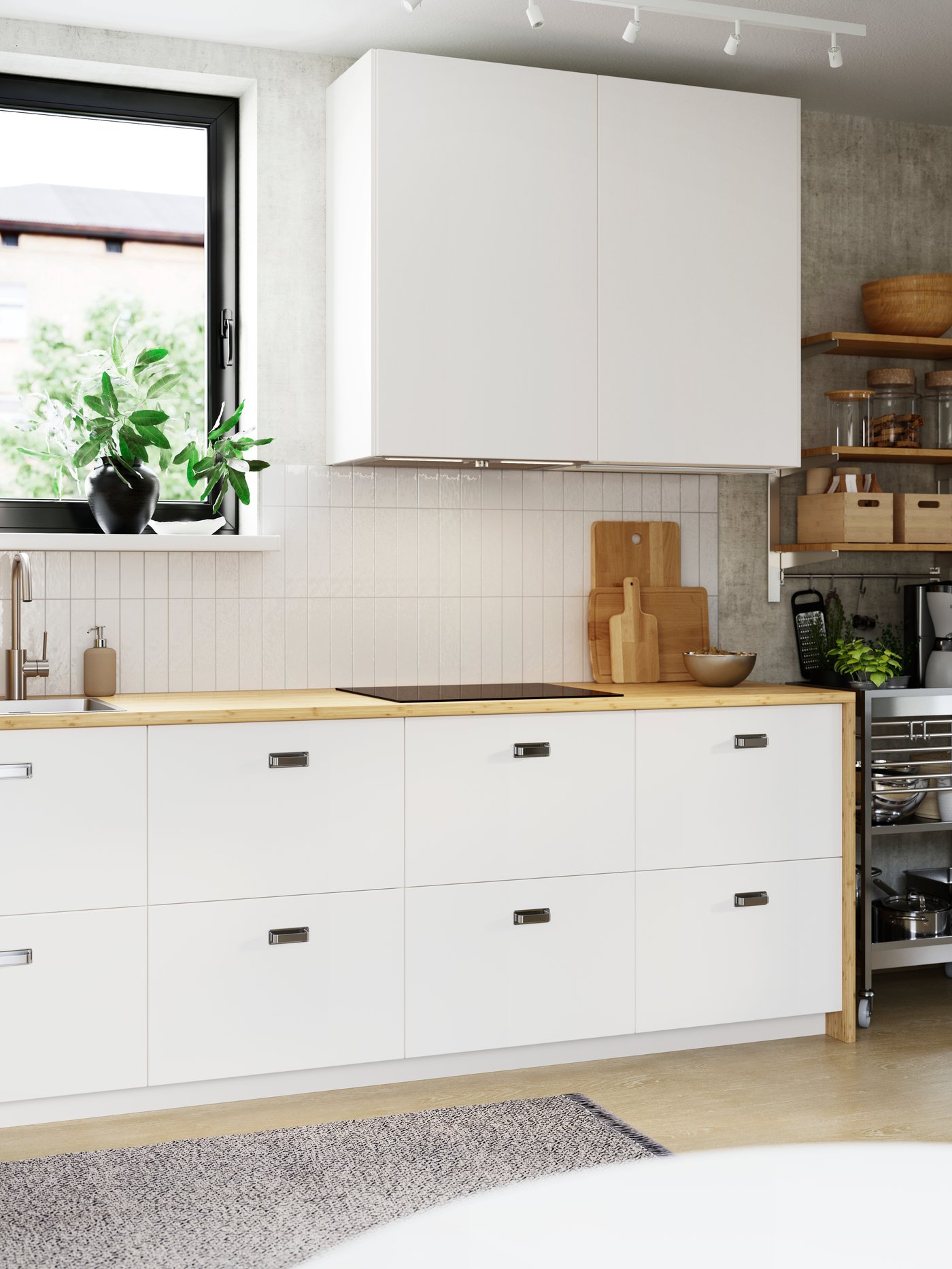 Un mur de cuisine carrelé blanc et lumineux comporte deux armoires hautes et huit tiroirs spacieux avec des façades lisses et blanches VEDDINGE.