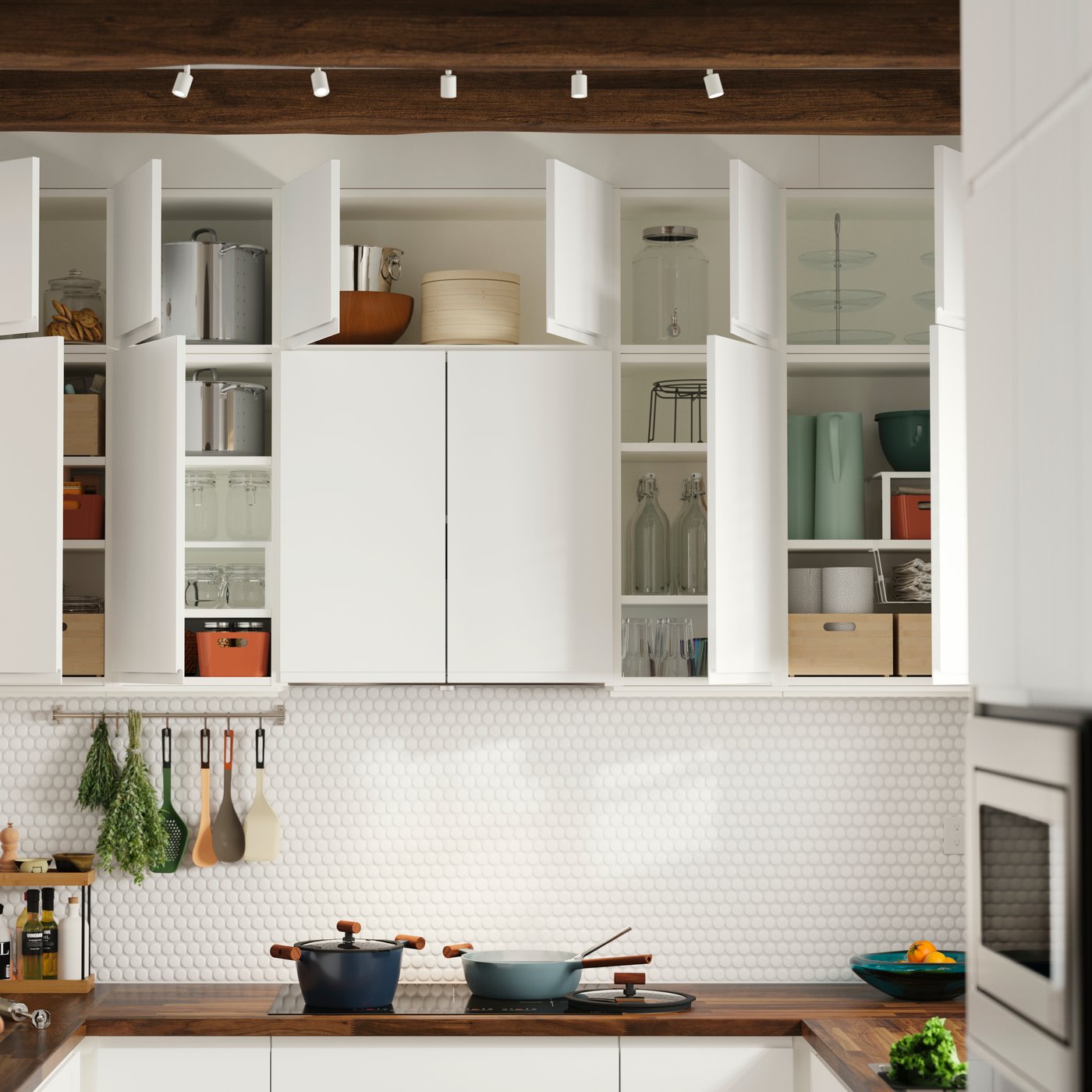 Wall-mounted kitchen cabinets have matte white VOXTORP doors and some of them have been opened, showing items stored inside.