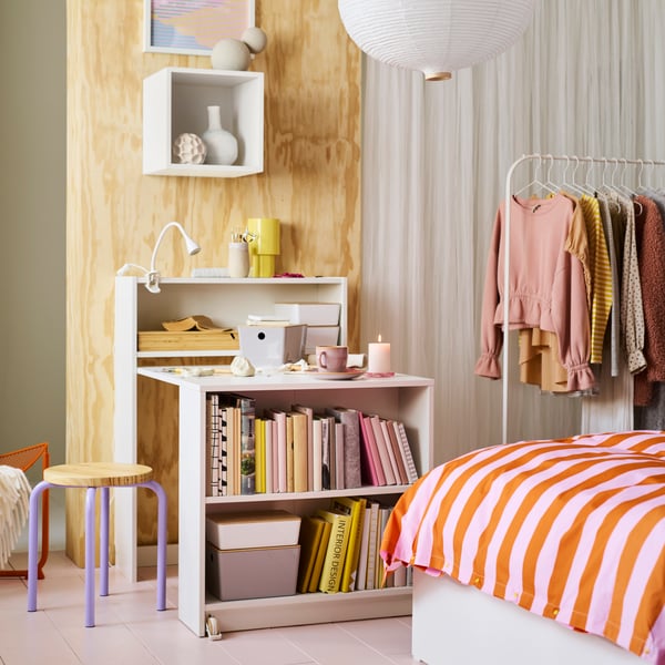 A lilac/pine DOMSTEN stool next to a white BILLY bookcase with foldable table. The table has various craft materials on top.